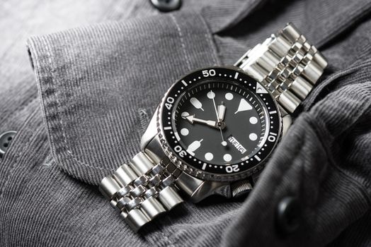 Close up men dive watch with stainless steel bracelet, luxury wristwatch for men.