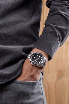 The man posing with dive watch with stainless steel bracelet.