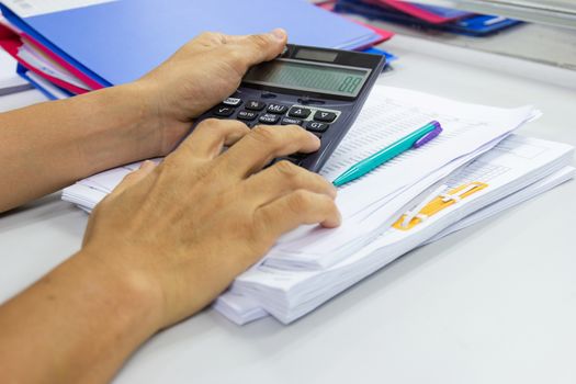 Employees use office calculators with documents of income, expenses, concept of life at work.