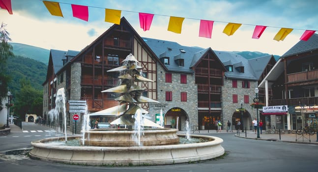 Saint-Lary-Soulan, France - August 20, 2018: atmosphere and architecture in the city center where people go for a walk on a summer day