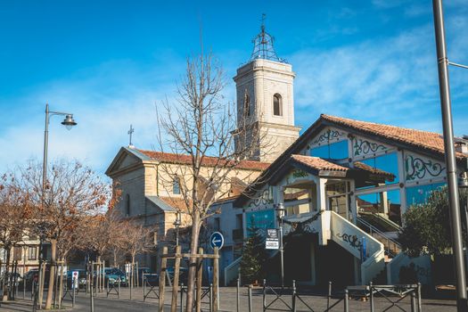 Marseillan, France - December 30, 2018: architectural detail of the Saint Jean-Baptiste church and the La Fabrique media library in the historic city center on a winter day