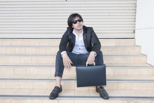Unemployed asian businessman stress in city outdoor sit on stair