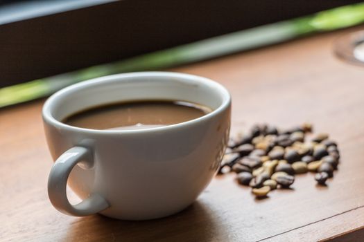 Coffee in the cup on wooden bar.In coffee shop.