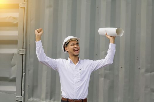 Young Asia man engineer wearing safety white helmet in white shirt checking construction site building,so happy.