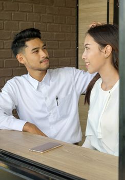 Asian young couple in love at a coffee shop, they are smile. Conception in coffee shop.