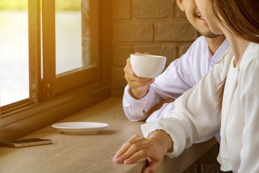 Asian young couple in love at a coffee shop, they are smile. Conception in coffee shop.