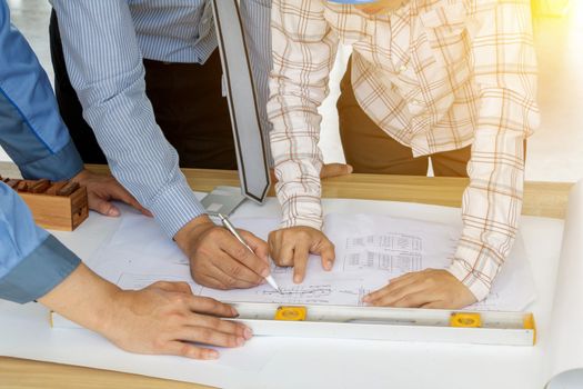 A group of engineers are looking at a blueprint for construction on the table. Engineering concept.