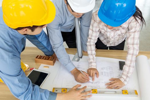 A group of engineers are looking at a blueprint for construction on the table. Engineering concept.