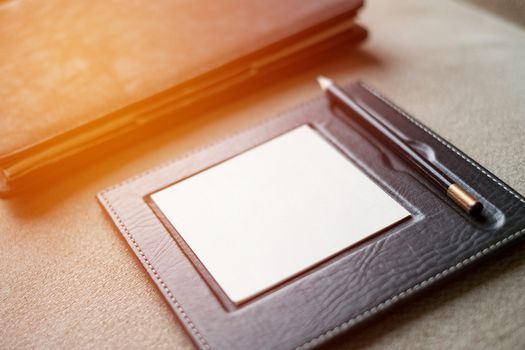 Black leather note book with pencil on carpet background