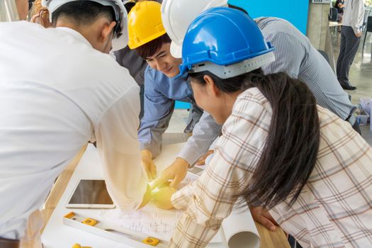 A group of engineers are looking at a blueprint for construction on the table. Engineering concept.