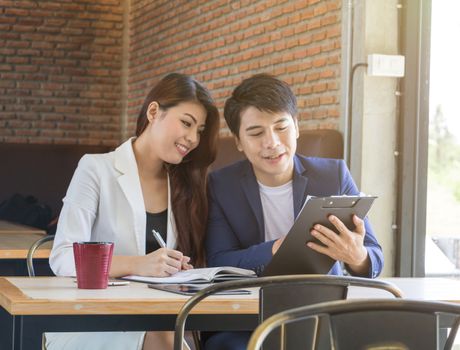 Asian business man and asian business woman in coffee shop.