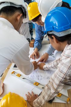 A group of engineers are looking at a blueprint for construction on the table. Engineering concept.