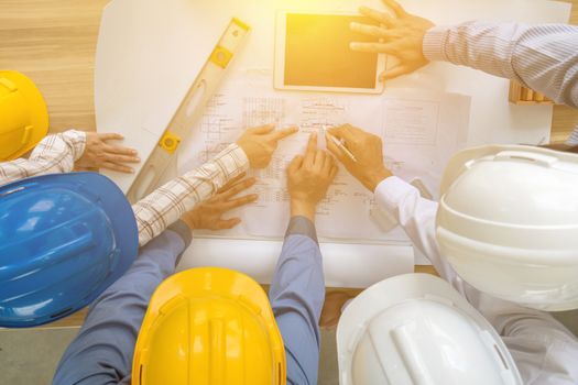 A group of engineers are looking at a blueprint for construction on the table,Top view. Engineering concept.