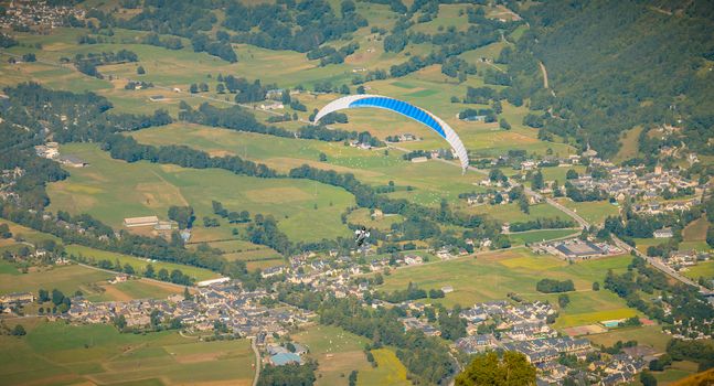 Saint Lary Soulan, France - August 20, 2018: paragliding in flight at the top of the mountain at 1700 meters above sea level flying over the valley on a summer day