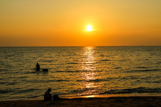 silhouette child play on beach and sunset background