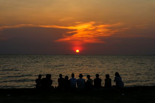 silhouette people family and pet meeting at beach and sea sand sunset background