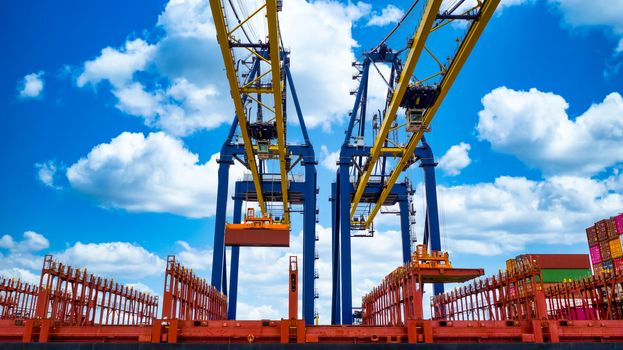 Quay crane, Crane of container terminal in industrial sea port, Sea cargo port with container ship and crane with blue sky background, Business logistic import export transportation by cargo vessel.