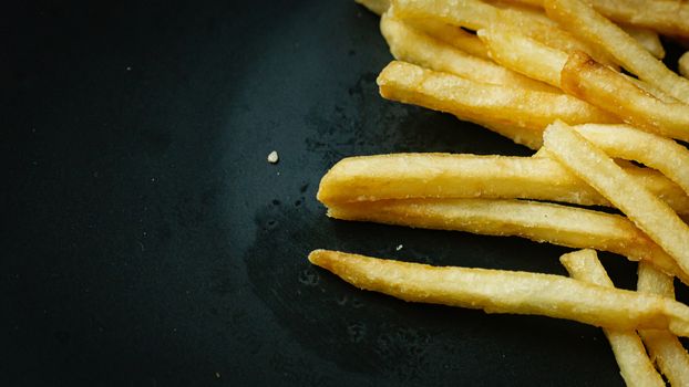 The French fries on black plate for food content.