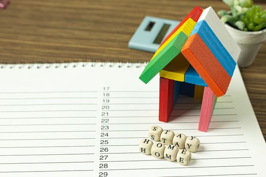 The stay home on wood cube and home toy for social distancing content.