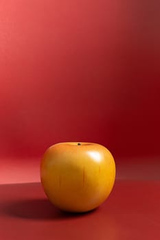 A apple on red background low light for food content.
