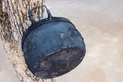 Old black pot at through the use of cooking for a long time hang on tree.