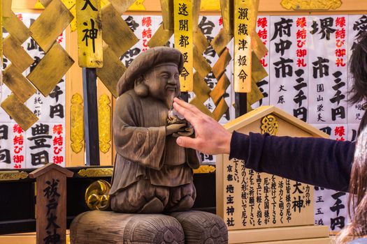 KYOTO, JAPAN - MARCH 12, 2018: Tourist at Kiyomizu-dera temple use your hands to touch God Harada Edo Okami for pray a god who purifies the body and mind in Kyoto, Japan.