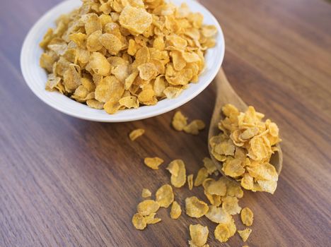 Corn flakes and bowl on wood table