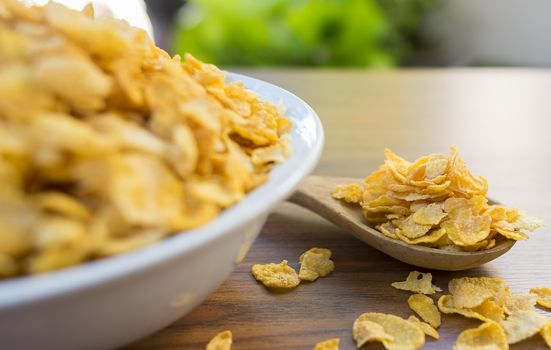 Corn flakes and bowl on wood table