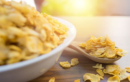 Corn flakes and bowl on wood table