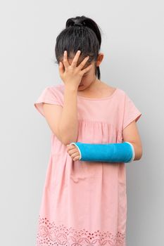 Asian Child with Broken Arm in Cast with Hurting and Sad Face Expression