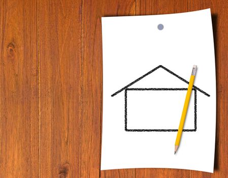 Building new house, home concept, white paper and yellow pencil on wood background 