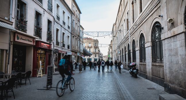 Sete, France - January 4, 2019: People walking in a shopping street in the historic city center on a winter day