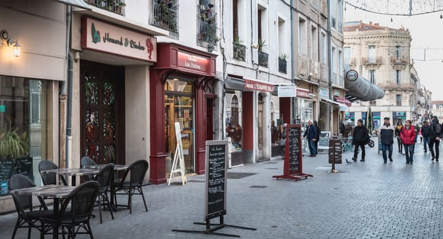 Sete, France - January 4, 2019: People walking in a shopping street in the historic city center on a winter day