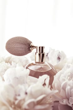 Retro fragrance bottle as luxury perfume product on background of peony flowers, parfum ad and beauty branding design