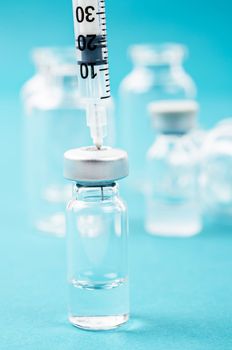 Vaccine vial dose with needle syringe, medical concept vaccination in laboratory background.