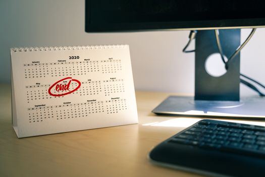 Selective focus on a home office desk with a calendar sheet and the month of June marked on it. Concept of probable end date of coronavirus lockdown or Telecommuting from home.