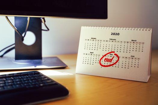 Selective focus on a home office desk with a calendar sheet and the month of may marked on it. End date concept of situations like working from home or coronavirus lockdown by the autorities