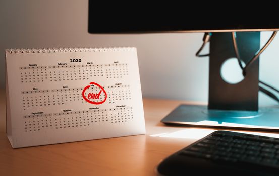 Selective focus on a home office desk with a calendar sheet and the month of June marked on it. Concept of probable deadline of coronavirus lockdown or Telecommuting from home.
