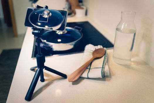 Food blogger streaming live on social media from home. Smart phone camera on a tripod, food blogger studio set