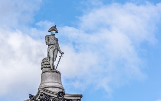 Statue of Admiral Nelson in London wearing a face mask as a symbol of the London and UK lockdown caused by coronavirus outbreak..