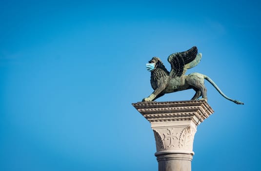 The Winged Lion of Venice wearing a face mask as a symbol of the Venice and Italy lockdown caused by coronavirus outbreak..