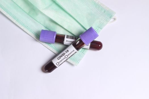 Simple Conceptual, Glass Blood Covid-19 Test tube, without result, above N95 Surgical Mask