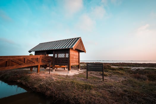 Wooden cabin or bird hut for bird watching in the Ebro river delta, Spain. Teal and orange style.