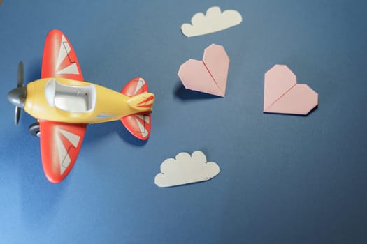 Airplane toy with origami pink hearts. Suitable for marriage, love or Valenine's Day concepts.