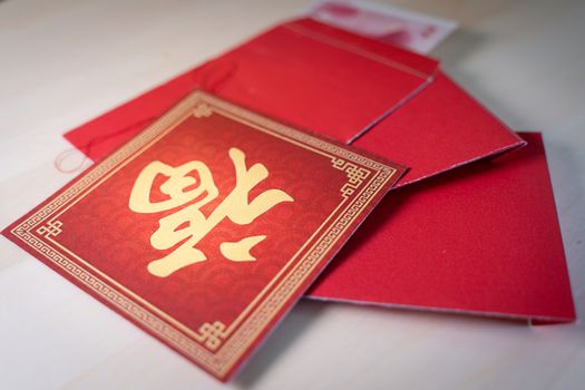 Chinese new year decoration with red envelopes and character FU displayed upside-down on diagonal red square, meaning good luck ,fortune and blessing.