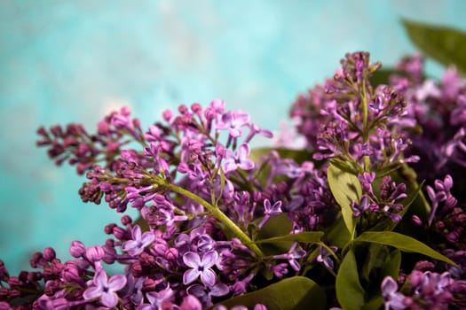 Purple lilac flowers bouquet on emerald background. Stylish floral greeting card. Happy mothers day.