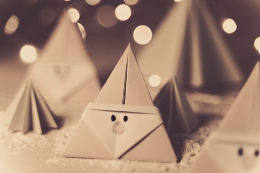 Origami Xmas scene with Santa claus and crhistmas trees in paper craft, sepia tone