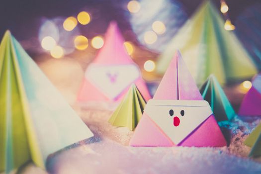 Origami Xmas scene with a pink Santa claus and crhistmas trees in paper craft