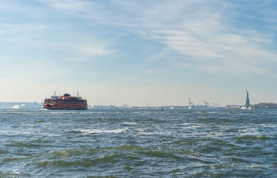 Staten Island Ferry cruises past the Statue of Liberty in New York City, NY.