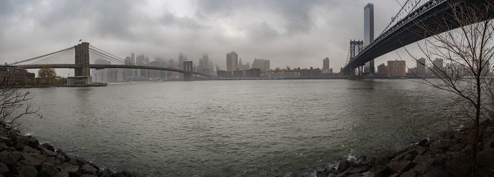 New York City Manhattan skyline panorama with Brooklyn Bridge and Manhattan Bridge viewed from the neighborhood known as DUMBO